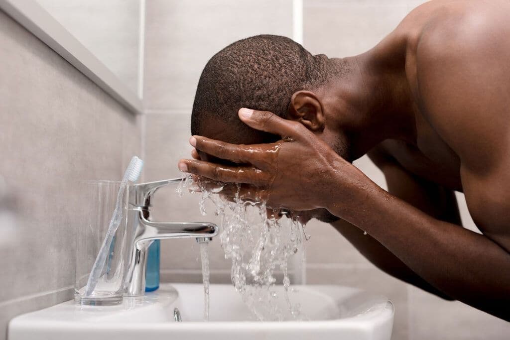 side view of you man washing face