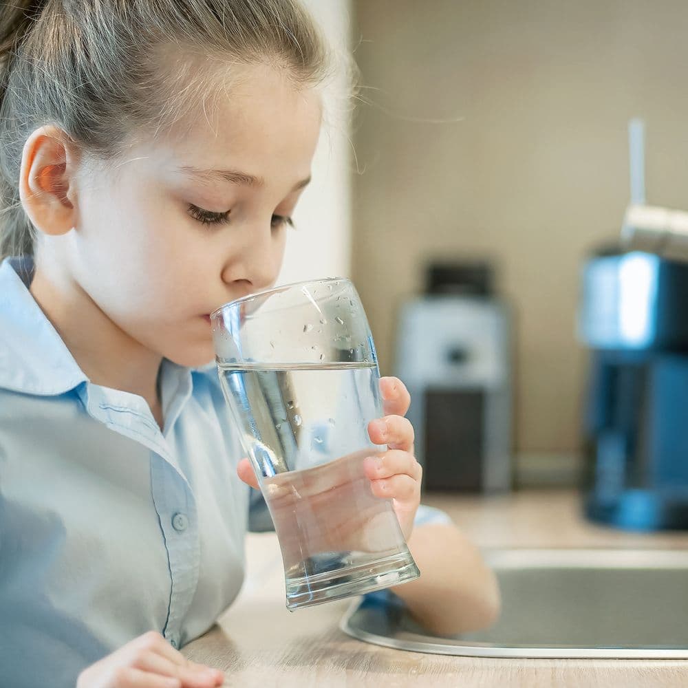 A child drinks a glass of water.