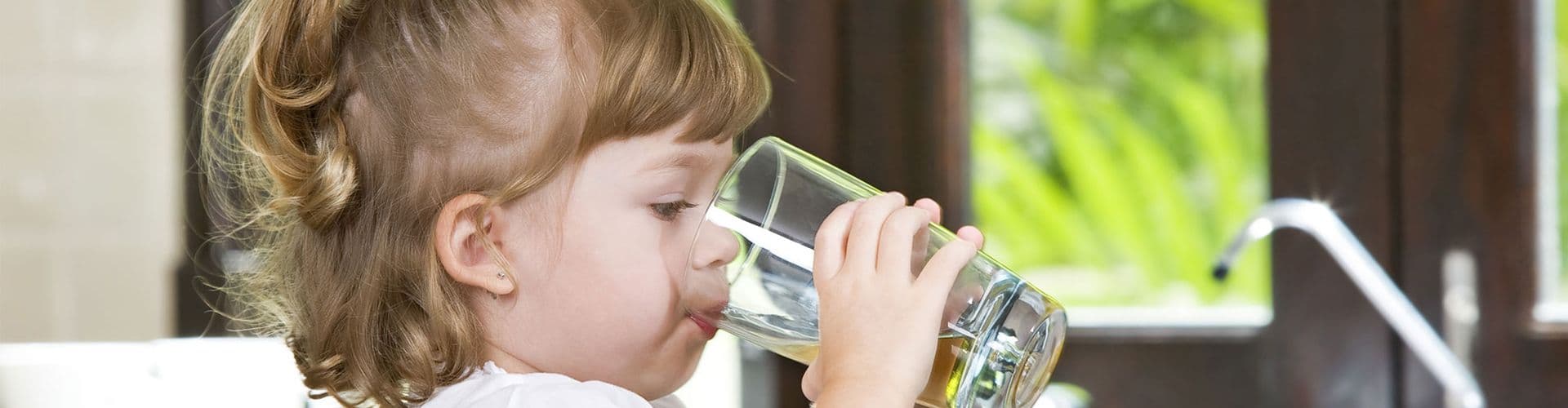 A child drinks a glass of water.